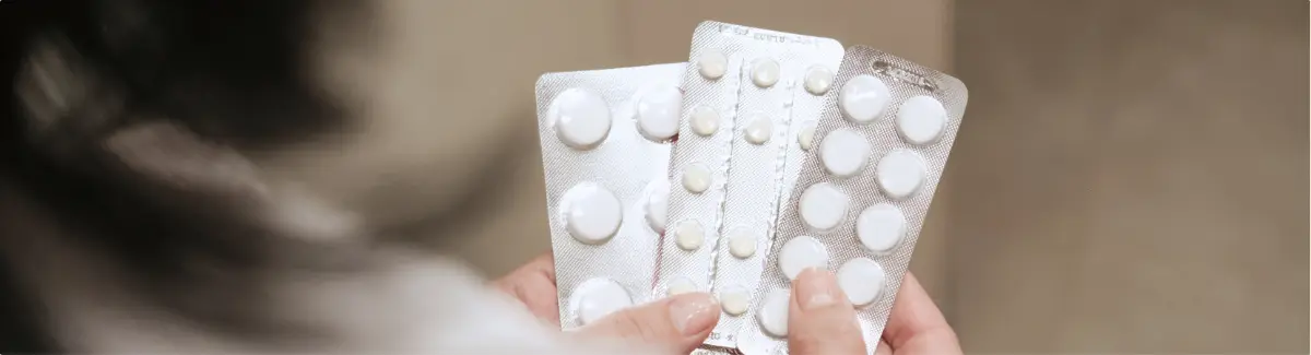 Person holding blister packs of prescription pills.