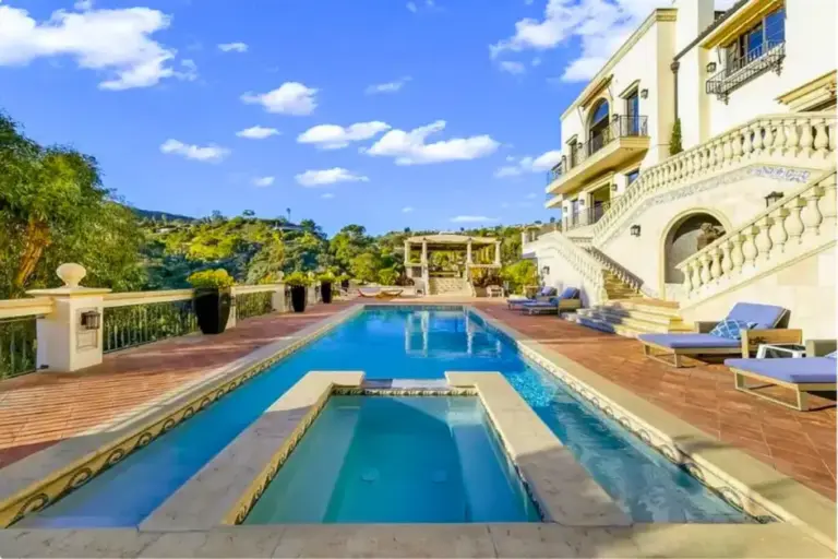 Outdoor infinity pool and sun loungers at a luxury rehab with concierge-level amenities.